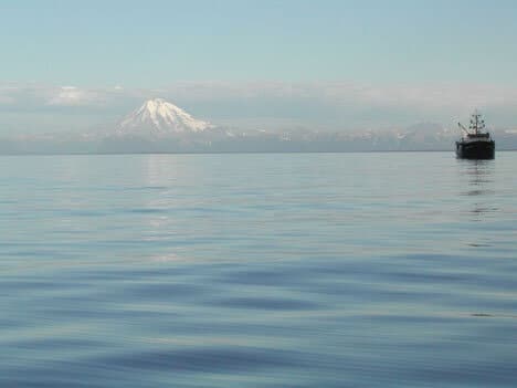 Ship on water in front of volcano view